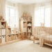 Vue d’ensemble réaliste d’une chambre de bébé lumineuse avec mobilier évolutif en bois clair, rangements organisés et décoration douce aux tons pastel.
