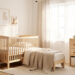 Chambre de bébé lumineuse et bien organisée avec mobilier en bois clair, rangements sobres et ambiance douce.